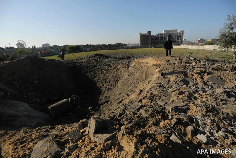 Palestinian men inspect the damage to a soccer field post after it was hit by an Israeli airstrike, on the outskirts of Gaza City December 1, 2017. Photo by Ashraf Amra