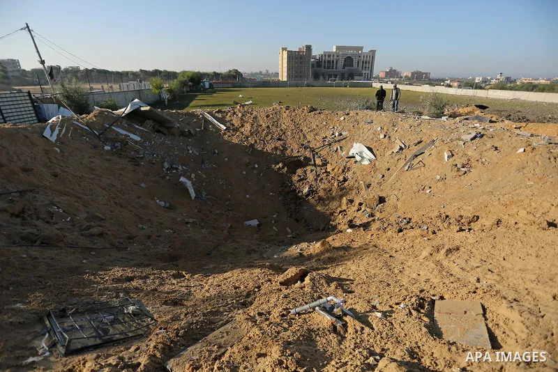 Palestinian men inspect the damage to a soccer field post after it was hit by an Israeli airstrike, on the outskirts of Gaza City December 1, 2017. Photo by Ashraf Amra