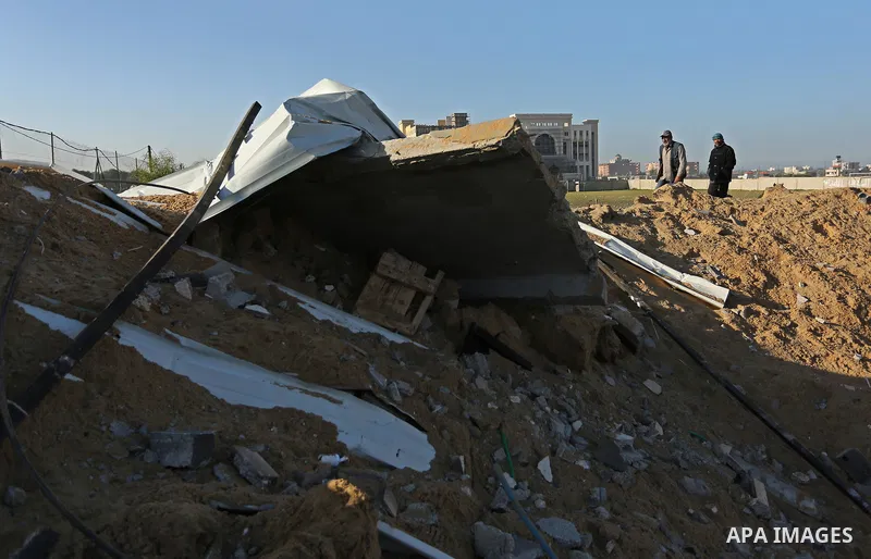 Palestinian men inspect the damage to a soccer field post after it was hit by an Israeli airstrike, on the outskirts of Gaza City December 1, 2017. Photo by Ashraf Amra