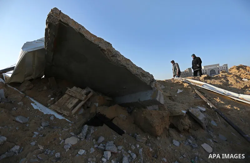Palestinian men inspect the damage to a soccer field post after it was hit by an Israeli airstrike, on the outskirts of Gaza City December 1, 2017. Photo by Ashraf Amra