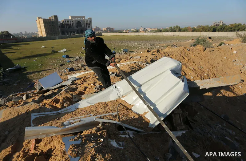 Palestinian men inspect the damage to a soccer field post after it was hit by an Israeli airstrike, on the outskirts of Gaza City December 1, 2017. Photo by Ashraf Amra