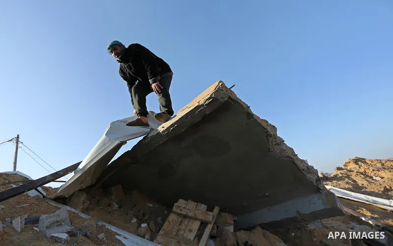 Palestinian men inspect the damage to a soccer field post after it was hit by an Israeli airstrike, on the outskirts of Gaza City December 1, 2017. Photo by Ashraf Amra