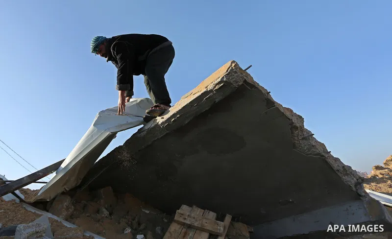 Palestinian men inspect the damage to a soccer field post after it was hit by an Israeli airstrike, on the outskirts of Gaza City December 1, 2017. Photo by Ashraf Amra