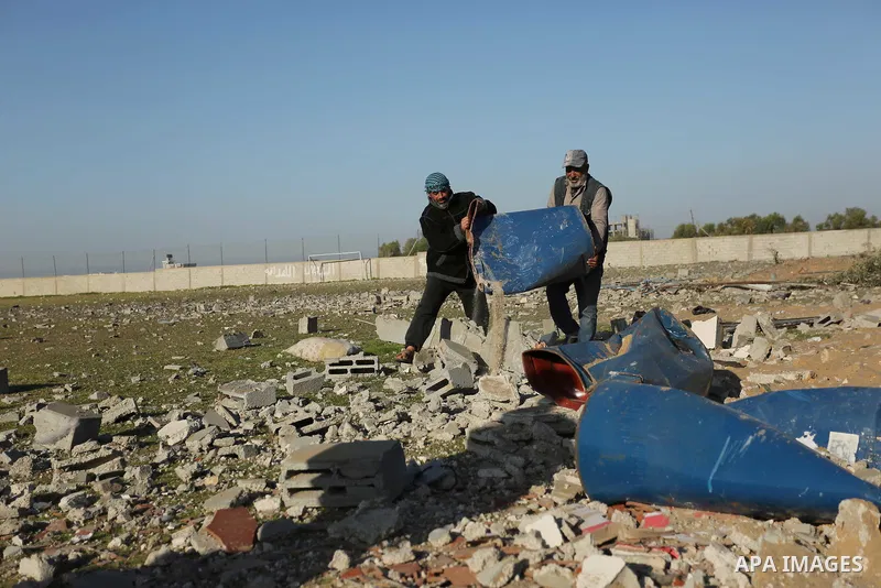 Palestinian men inspect the damage to a soccer field post after it was hit by an Israeli airstrike, on the outskirts of Gaza City December 1, 2017. Photo by Ashraf Amra