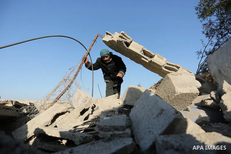 Palestinian men inspect the damage to a soccer field post after it was hit by an Israeli airstrike, on the outskirts of Gaza City December 1, 2017. Photo by Ashraf Amra
