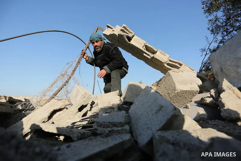 Palestinian men inspect the damage to a soccer field post after it was hit by an Israeli airstrike, on the outskirts of Gaza City December 1, 2017. Photo by Ashraf Amra