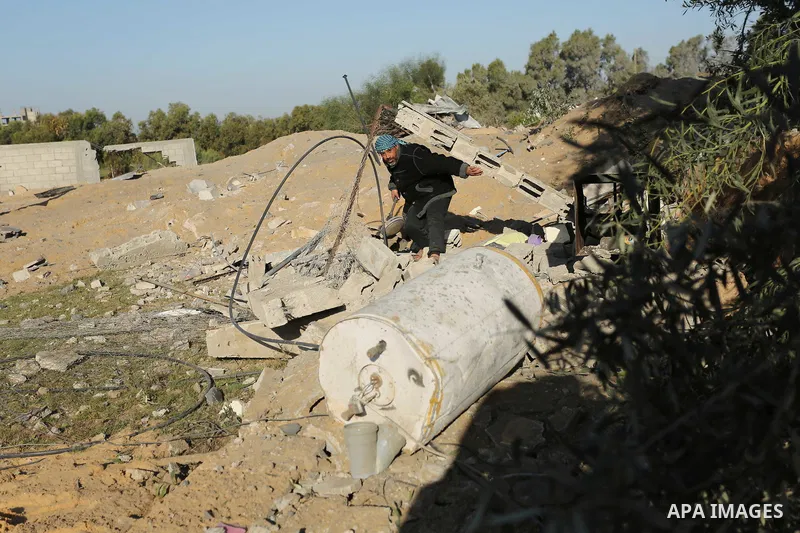Palestinian men inspect the damage to a soccer field post after it was hit by an Israeli airstrike, on the outskirts of Gaza City December 1, 2017. Photo by Ashraf Amra
