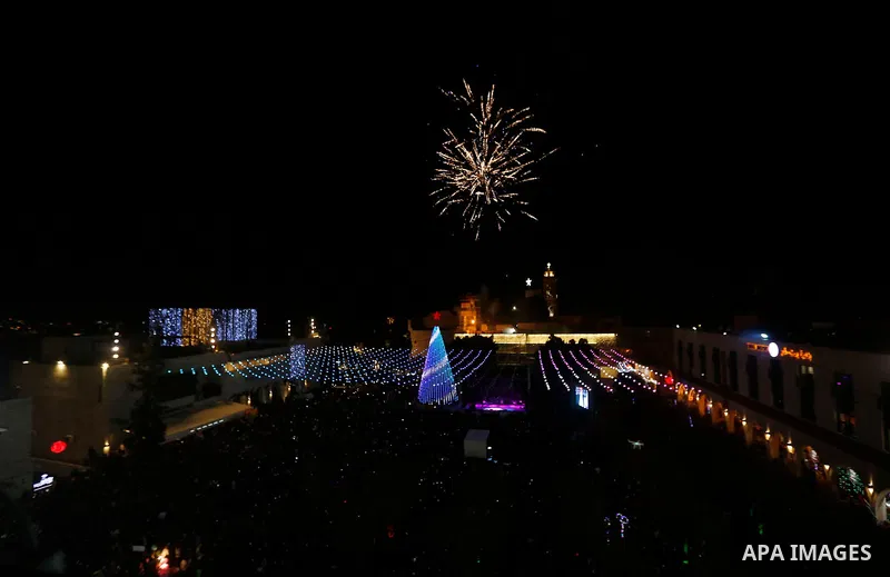 Fireworks explode during a Christmas tree lighting ceremony outside the Church of the Nativity in the West Bank town of Bethlehem, December 2, 2017. Photo by Wisam Hashlamoun