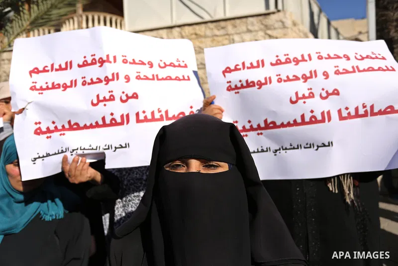 Palestinians hold placards during a demonstration against the siege, in front of Palestinian government headquarters in Gaza City on December 4, 2017. Photo by Ashraf Amra