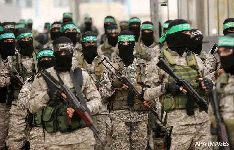 Members of the Ezzedine al-Qassam Brigades, the military wing of the Palestinian Islamist movement Hamas take part during a military parade ahead of the 30th anniversary of Hamas' founding, in Khan Younis in the southern...