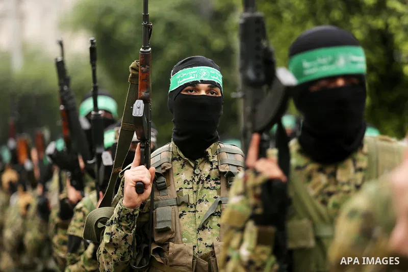 Members of the Ezzedine al-Qassam Brigades, the military wing of the Palestinian Islamist movement Hamas take part during a military parade ahead of the 30th anniversary of Hamas' founding, in Khan Younis in the southern...