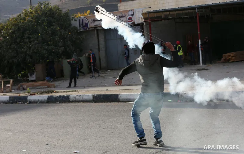 Palestinians throws stones at Israeli troops during clashes in Hawara checkpoint, south of the West Bank city of Nablus, following a demonstration against US President Donald Trump's decision to recognise Jerusalem as th...