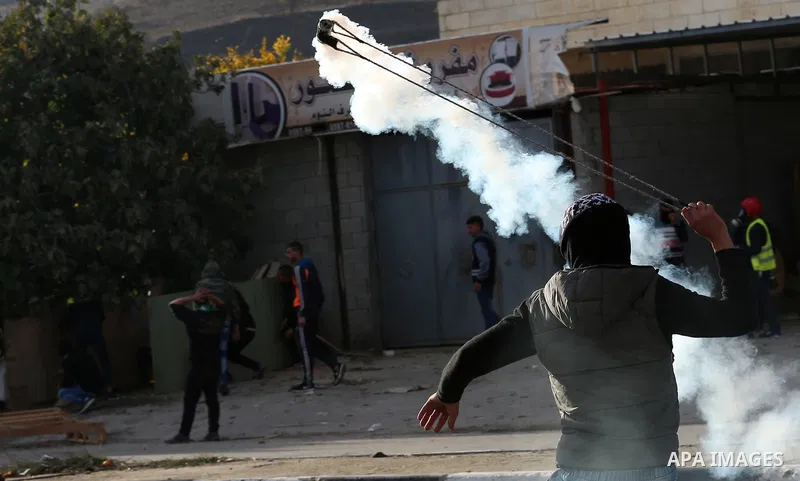 Palestinians throws stones at Israeli troops during clashes in Hawara checkpoint, south of the West Bank city of Nablus, following a demonstration against US President Donald Trump's decision to recognise Jerusalem as th...