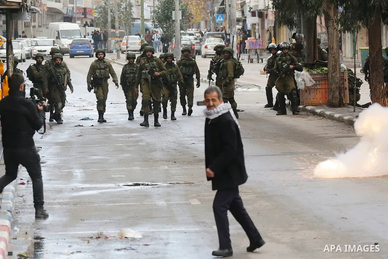 Palestinians clash with Israeli troops during a protest against U.S. President Donald Trump's decision to recognize Jerusalem as the capital of Israel in the West Bank City of Hebron, Thursday, Dec. 7, 2017. Photo by Wis...