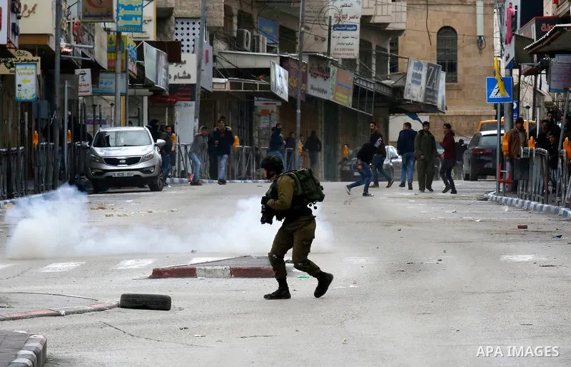 Palestinians clash with Israeli troops during a protest against U.S. President Donald Trump's decision to recognize Jerusalem as the capital of Israel in the West Bank City of Hebron, Thursday, Dec. 7, 2017. Photo by Wis...