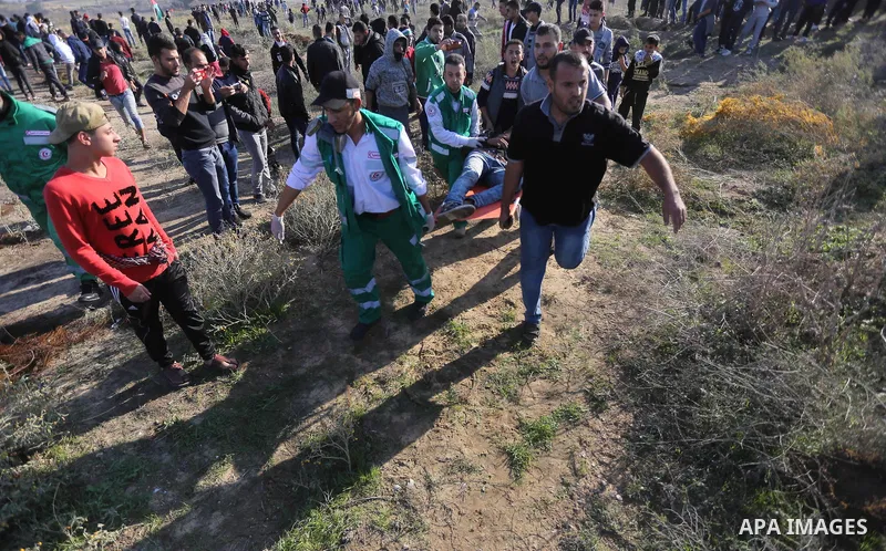 Palestinian protesters carry a wounded comrade during clashes with Israeli forces on December 8, 2017 near the border fence with Israel, east of Gaza City. Palestinians clashed with Israeli security forces after calls fo...
