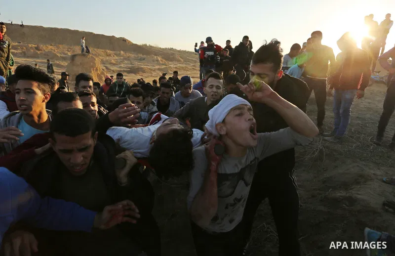 A wounded Palestinian protester is evacuated during clashes with Israeli forces at the Bureij refugee camp, in central Gaza on December 8, 2017. Palestinians clashed with Israeli security forces after calls for a "day of...