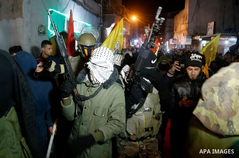 Masked Palestinian militants from Al Aqsa Martyrs' Brigade, a militia linked to the Fatah movement hold their weapons during a protest against US President Donald Trump's decision to recognise Jerusalem as the capital of...