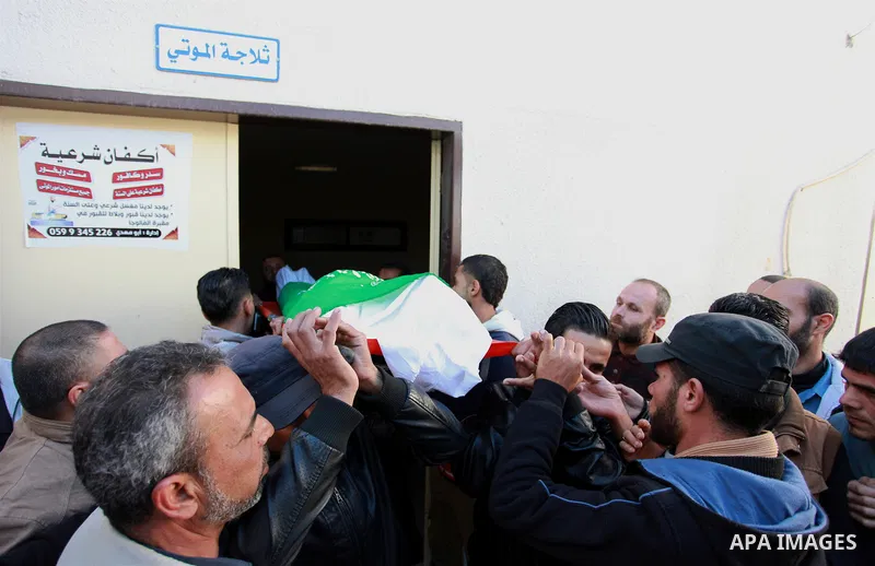 Palestinian mourners carry the body of Maher Atallah a 54-year-old Palestinian man who was killed the previous day in clashes with Israeli troops, during his funeral in Beit Lahia, in the northern Gaza Strip, on December...