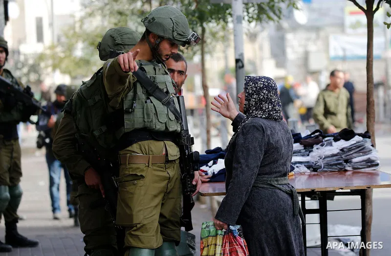 A Palestinian woman argues with Israeli security forces during clashes in the city centre of the West Bank town of Hebron on December 10, 2017. New protests flared in the Middle East and elsewhere over US President Donal...