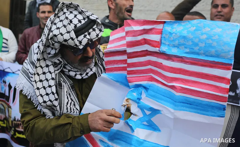 Palestinians burn an Israeli flag and a U.S. flag during a protest against Trump's decision to recognize Jerusalem as the capital of Israel, in Gaza City December 11, 2017. Photo by Ashraf Amra