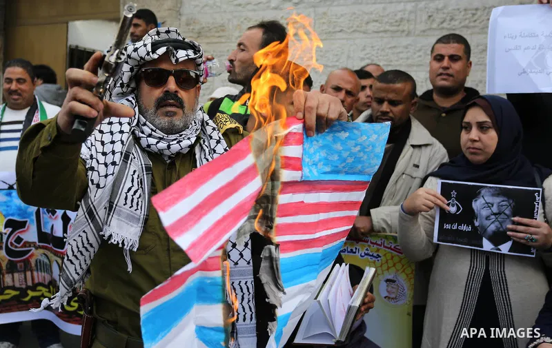 Palestinians burn an Israeli flag and a U.S. flag during a protest against Trump's decision to recognize Jerusalem as the capital of Israel, in Gaza City December 11, 2017. Photo by Ashraf Amra