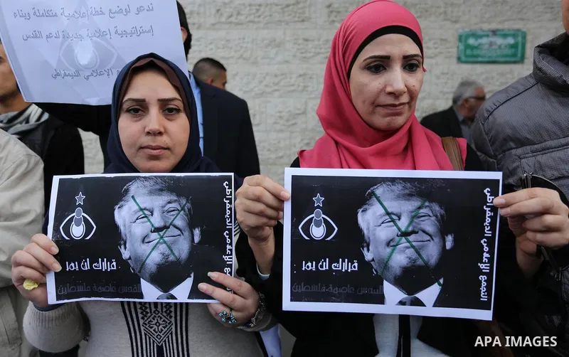 Palestinians burn an Israeli flag and a U.S. flag during a protest against Trump's decision to recognize Jerusalem as the capital of Israel, in Gaza City December 11, 2017. Photo by Ashraf Amra