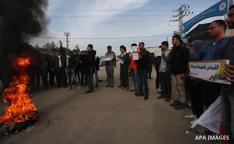 Palestinian demonstrators burn tires during a protest against what organizers said was a visit by a group of Bahraini people to Israel, in the northern Gaza Strip December 11, 2017. Photo by Mohammed Dahman