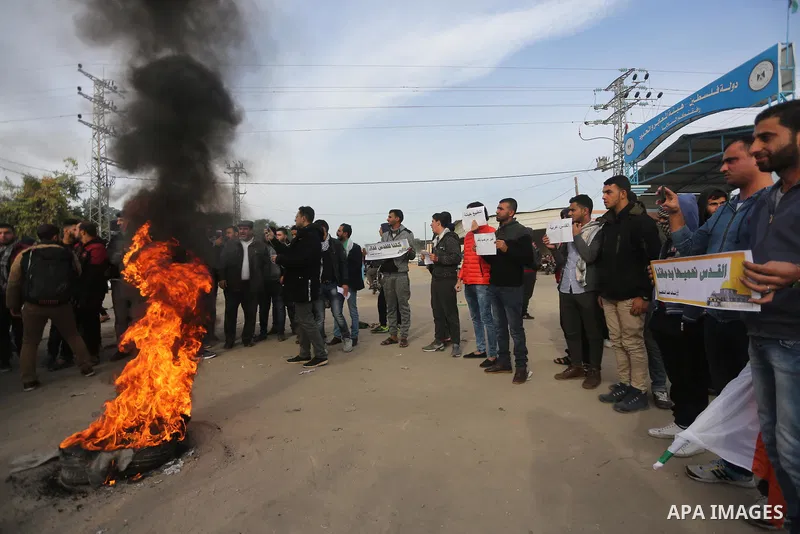 Palestinian demonstrators burn tires during a protest against what organizers said was a visit by a group of Bahraini people to Israel, in the northern Gaza Strip December 11, 2017. Photo by Mohammed Dahman