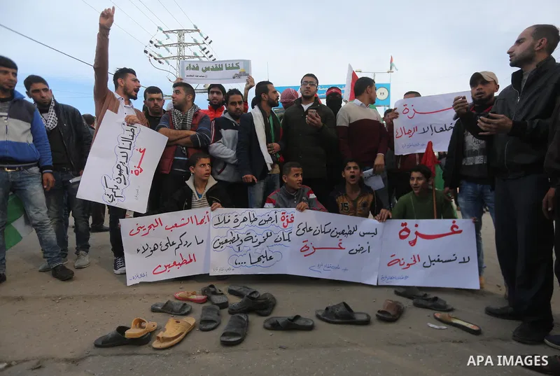 Palestinian demonstrators hold banners during a protest against what organizers said was a visit by a group of Bahraini people to Israel, in the northern Gaza Strip December 11, 2017. Photo by Mohammed Dahman