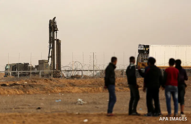 Palestinian protesters clash with Israeli security forces near the Israel-Gaza border east of the southern Gaza strip city of Khan Yunis on December 12, 2017 with Israeli heavy machinery seen in the background on the oth...
