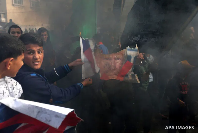 Palestinians burn posters depicting U.S. President Donald Trump during a protest against US President Donald Trump's decision to recognise Jerusalem as the capital of Israel, in al-Bureij in the central of Gaza strip, on...