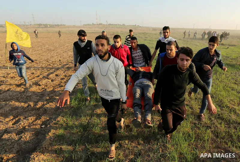 Palestinian protesters carry away an injured man during clashes with Israeli security forces near the border fence with Israel, east of Gaza City on December 16, 2017 as demonstrations continue over US President Donald T...