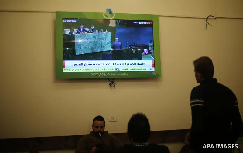 Palestinians watch a televised broadcast of the U.N. General Assembly emergency special session to vote on a draft resolution calling on the United States to withdraw its recognition of Jerusalem as Israel's capital, in...