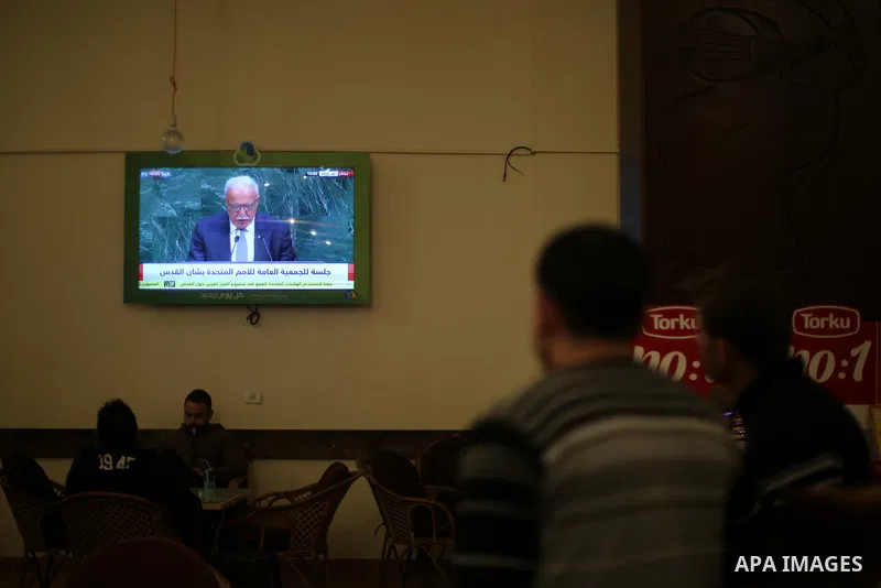 Palestinians watch a televised broadcast of the U.N. General Assembly emergency special session to vote on a draft resolution calling on the United States to withdraw its recognition of Jerusalem as Israel's capital, in...