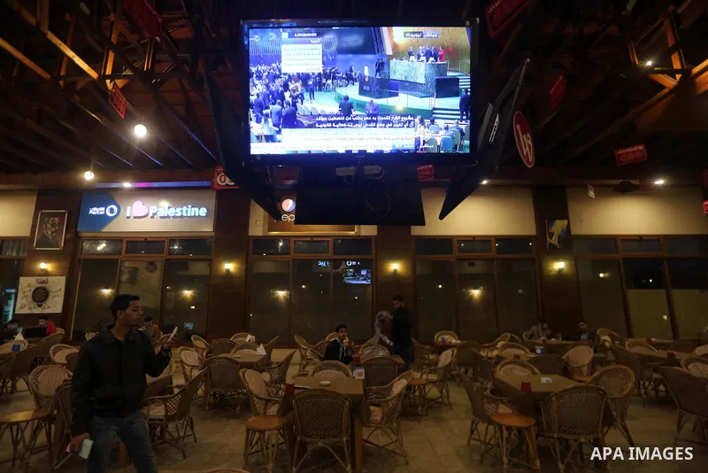 Palestinians watch a televised broadcast of the U.N. General Assembly emergency special session to vote on a draft resolution calling on the United States to withdraw its recognition of Jerusalem as Israel's capital, in...