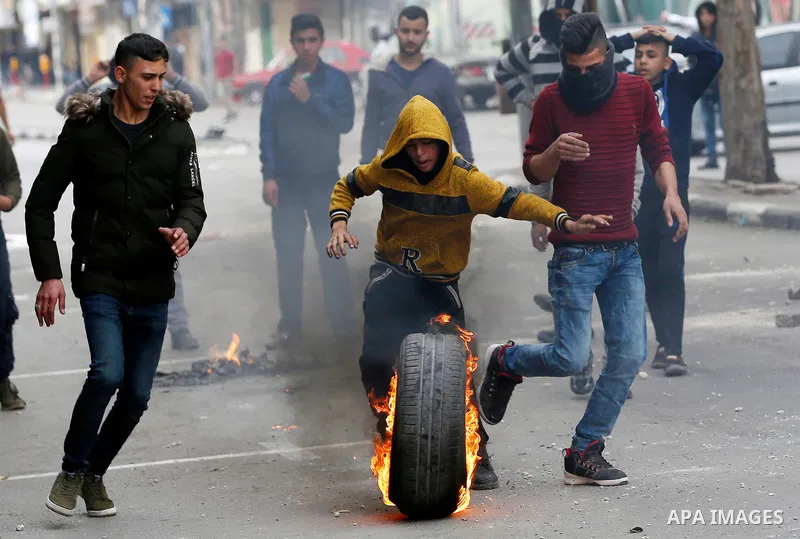 Palestinian protesters burn tires during clashes with Israeli security forces, at a protest as Palestinians call for a "Day of Rage" in response to U.S. President Donald Trump's recognition of Jerusalem as Israel's capit...