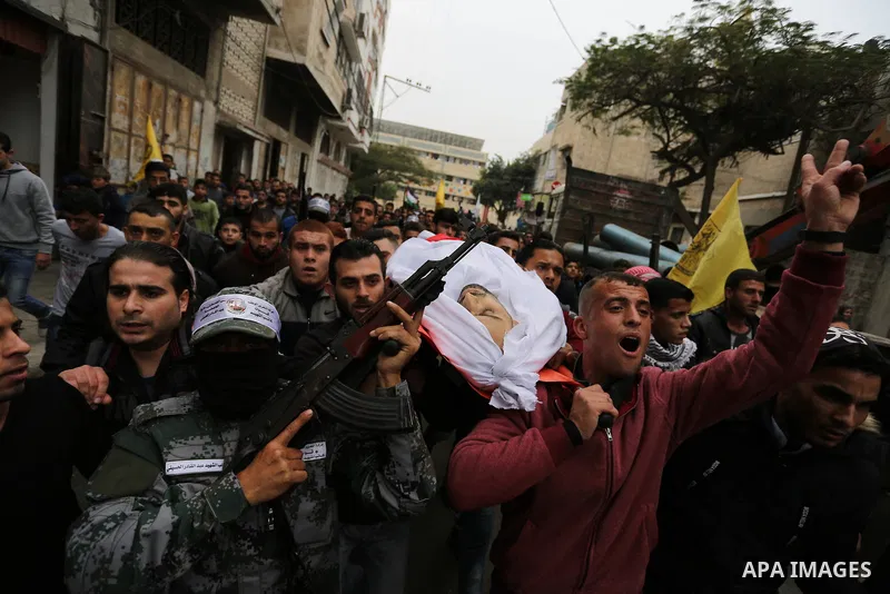 Palestinian mourners carry the body of Mohamed Moheisen, 29, who was killed during clashes with Israeli troops, during his funeral in Gaza city on December 23, 2017. Two Palestinians were killed as youths clashed with Is...