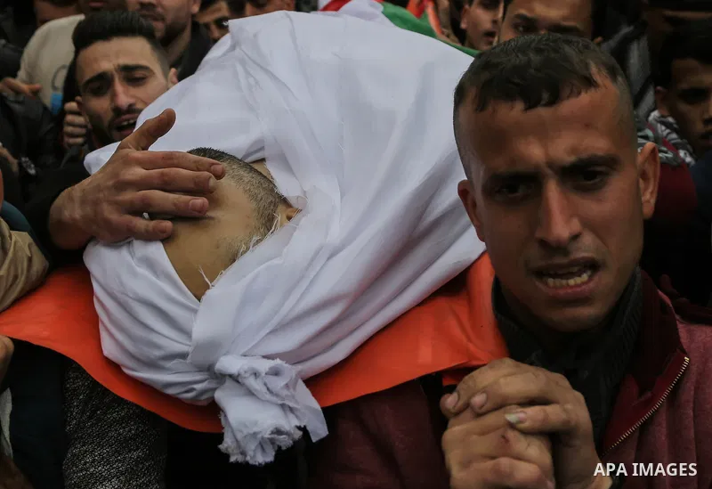 Palestinian mourners carry the body of Mohamed Moheisen, 29, who was killed during clashes with Israeli troops, during his funeral in Gaza city on December 23, 2017. Two Palestinians were killed as youths clashed with Is...