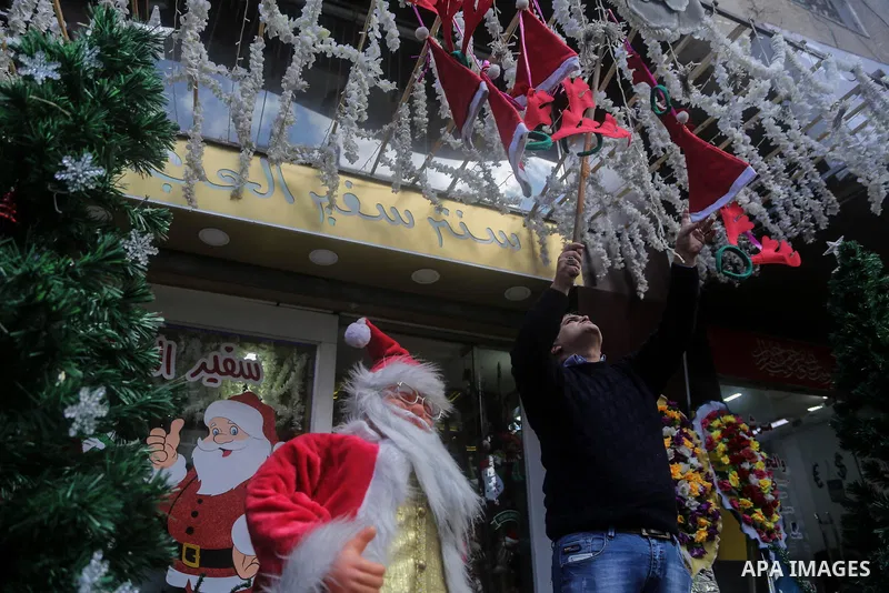 A Palestinian vendor displays decorations of New Year 2018, at his shop in Gaza city on December 25, 2017. Photo by Mohammed Dahman