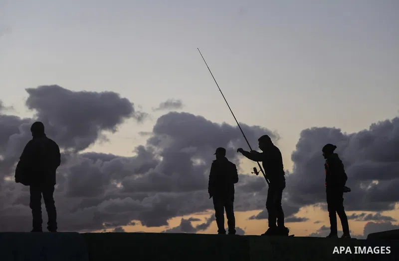 Palestinians enjoy during sunset at Gaza seaport on December 25, 2017. Photo by Mohammed Dahman