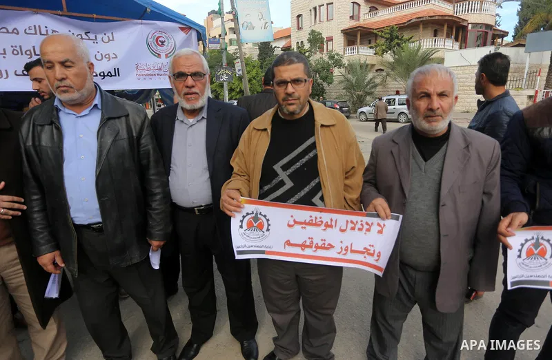 The Palestinian Authority employees in the Gaza Strip take part in a protest demanding their right, in front of the headquarters of the Council of Ministers in Gaza city on December 27, 2017. Photo by Mohammed Asad