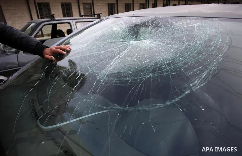 A Palestinian man inspects his car attacked by Israeli settlers in the West Bank village of Burin, near Nablus, on December 28, 2017. Photo by Ayman Ameen