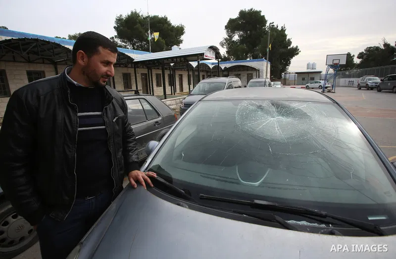 A Palestinian man inspects his car attacked by Israeli settlers in the West Bank village of Burin, near Nablus, on December 28, 2017. Photo by Ayman Ameen