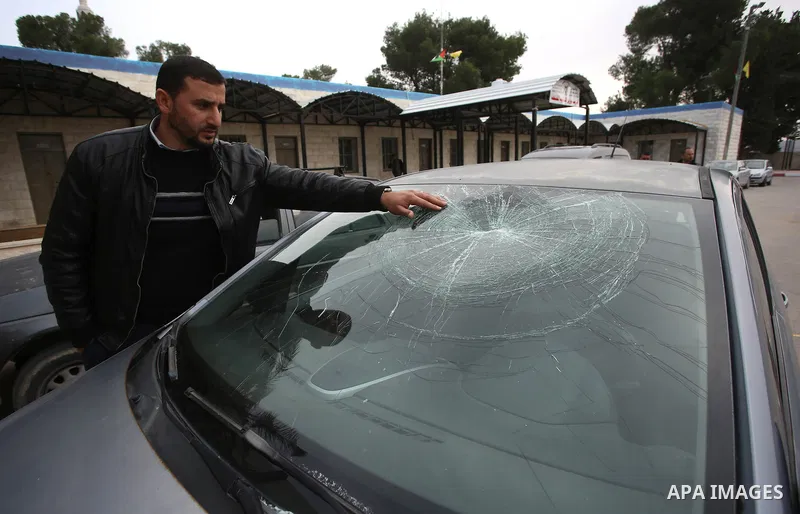 A Palestinian man inspects his car attacked by Israeli settlers in the West Bank village of Burin, near Nablus, on December 28, 2017. Photo by Ayman Ameen