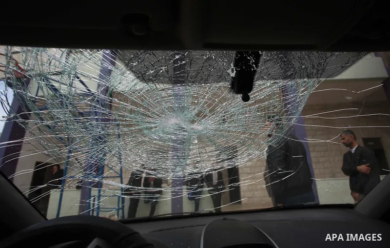A Palestinian man inspects his car attacked by Israeli settlers in the West Bank village of Burin, near Nablus, on December 28, 2017. Photo by Ayman Ameen