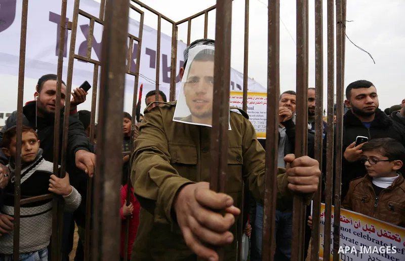 A Palestinian man playing the role of Israeli soldier Oron Shaul stands in a mock jail during a rally in solidarity with Palestinian prisoners held in Israeli jails, in the northern Gaza Strip December 29, 2017. Photo by...