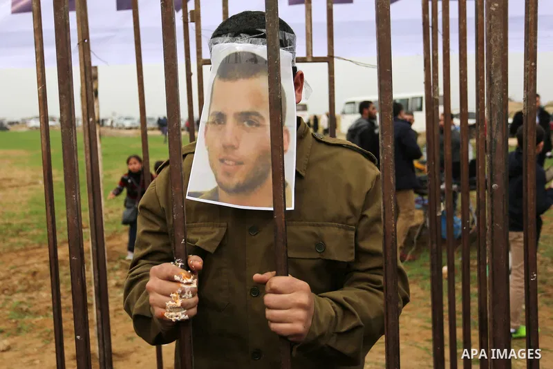 A Palestinian man playing the role of Israeli soldier Oron Shaul stands in a mock jail during a rally in solidarity with Palestinian prisoners held in Israeli jails, in the northern Gaza Strip December 29, 2017. Photo by...