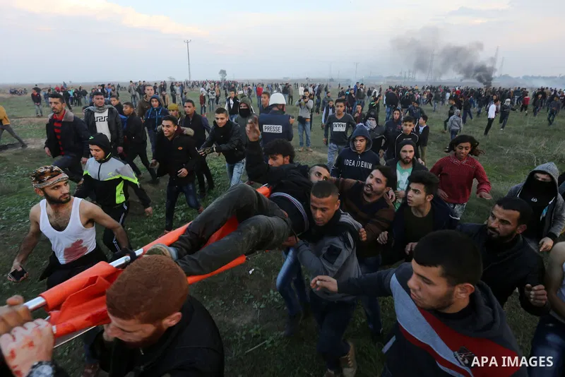 A wounded Palestinian demonstrator is evacuated during clashes with Israeli security forces near the Israel-Gaza border east of Gaza City on December 29, 2017, as demonstrations continue over the US president's controver...