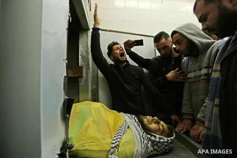 Relatives of Palestinian Jamal Mesleh, 21, who died of his injuries during clashes with Israeli security forces on Friday mourn over his body at a hospital morgue, in Dair Al Balah in the central Gaza Strip December 30,...